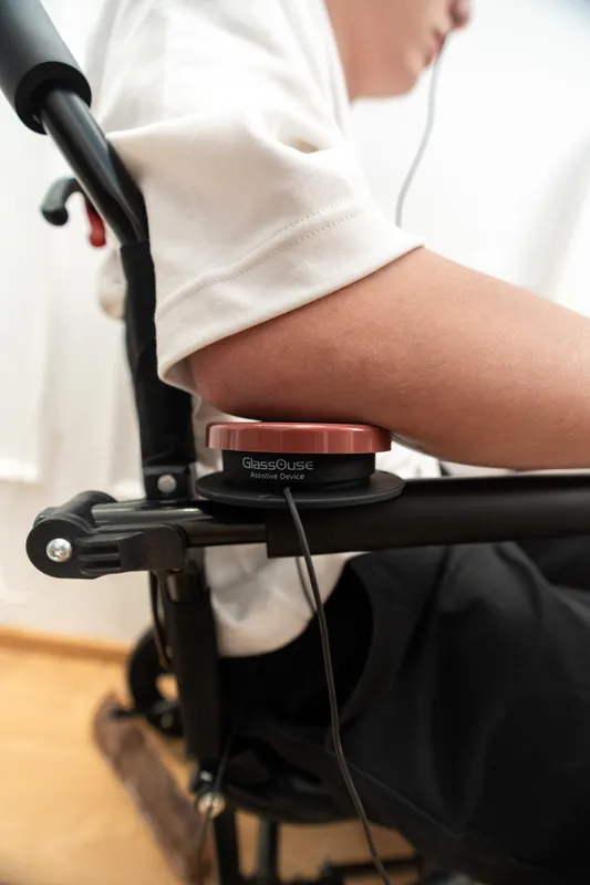 GlassOuse press switch mounted on wheelchair armrest for hands-free mobility aid control