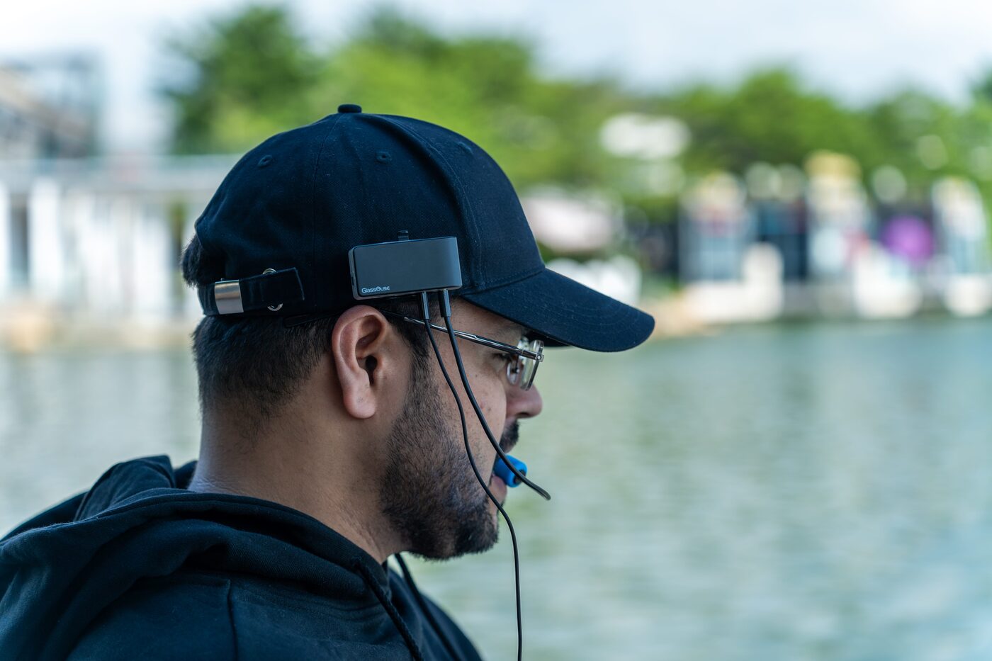 Person wearing GlassOuse PRO head mouse outdoors by the water
