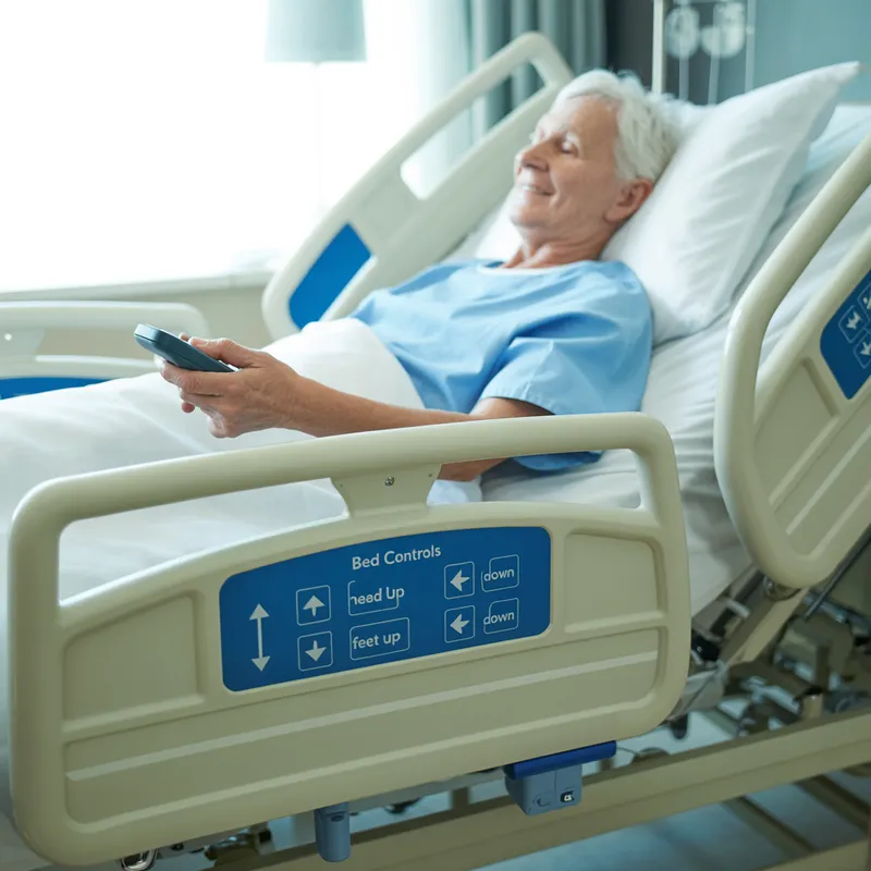 Elderly person in an adjustable hospital-style bed using a remote handset to control position